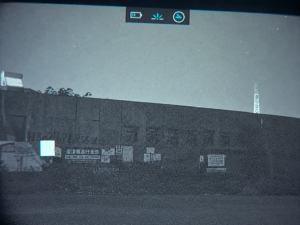 UVQ G14 view of a wall and distant signs in an urban low-light environment